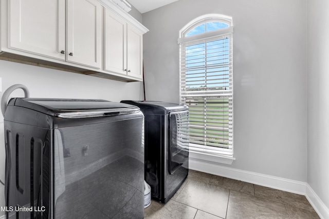 laundry area with washer and dryer, cabinet space, baseboards, and light tile patterned floors