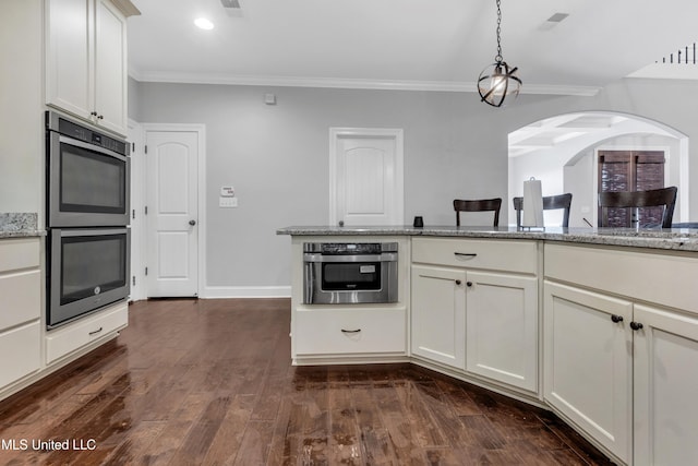 kitchen featuring stainless steel double oven, crown molding, light stone counters, pendant lighting, and arched walkways