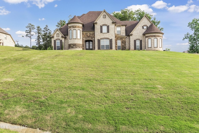 french country style house featuring a front lawn and brick siding