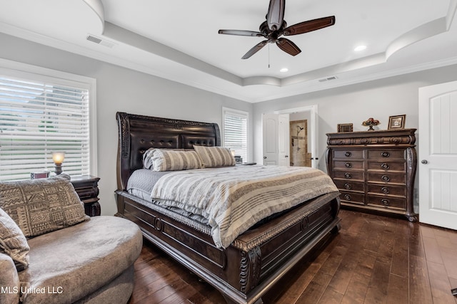 bedroom featuring a tray ceiling, dark wood-type flooring, recessed lighting, crown molding, and a ceiling fan