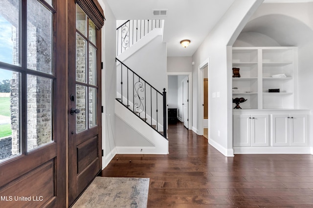 foyer entrance with stairway, baseboards, plenty of natural light, and dark wood-style floors