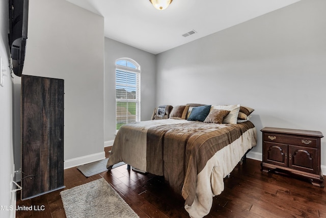 bedroom with baseboards and dark wood-style flooring
