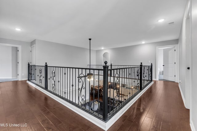 hallway with wood finished floors, an upstairs landing, baseboards, and recessed lighting