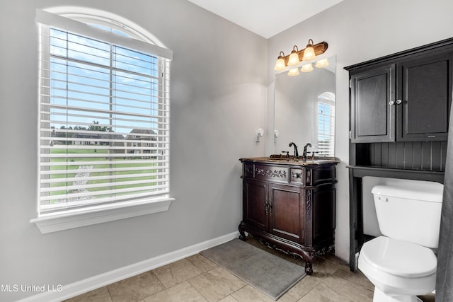 bathroom with baseboards, toilet, vanity, and tile patterned floors