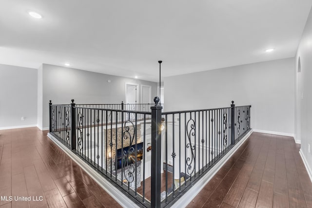 corridor with wood finished floors, recessed lighting, and baseboards