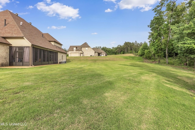 view of grassy yard with a sunroom