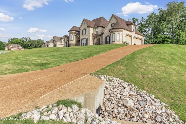 french country home with brick siding, a front lawn, and an attached garage