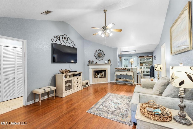 living room featuring hardwood / wood-style flooring, vaulted ceiling, and ceiling fan