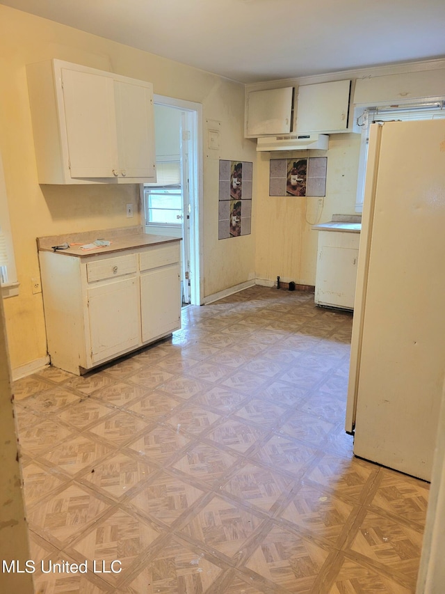 kitchen featuring light parquet floors, white refrigerator, and white cabinets