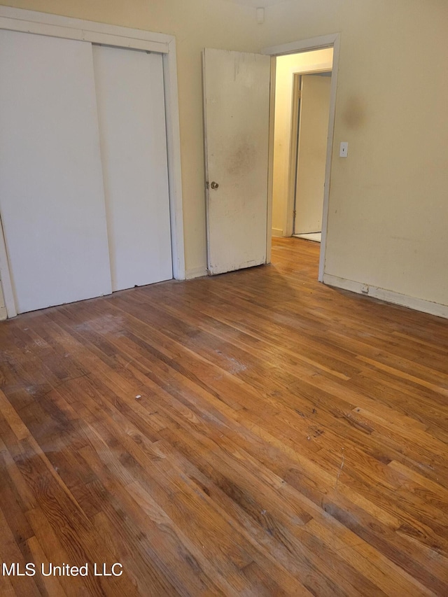 unfurnished bedroom with a closet and hardwood / wood-style flooring