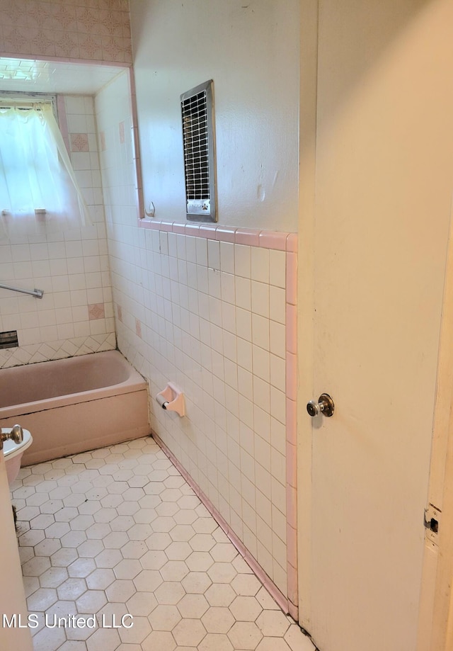 bathroom featuring a tub and tile walls