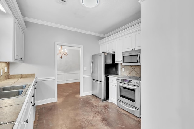 kitchen featuring tasteful backsplash, sink, white cabinets, ornamental molding, and stainless steel appliances