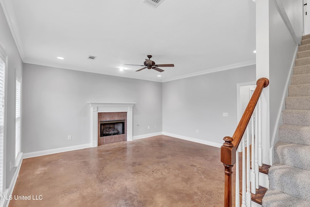 unfurnished living room with a tiled fireplace, ornamental molding, concrete floors, and ceiling fan