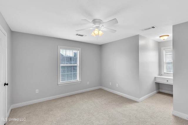 spare room with light colored carpet and ceiling fan