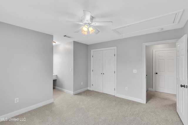 unfurnished bedroom featuring ceiling fan, a closet, and light carpet