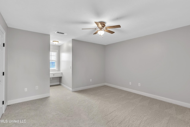 carpeted spare room featuring ceiling fan