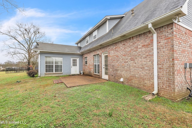 rear view of property with a yard and a patio area