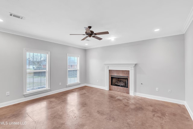 unfurnished living room featuring a tiled fireplace, crown molding, concrete floors, and ceiling fan