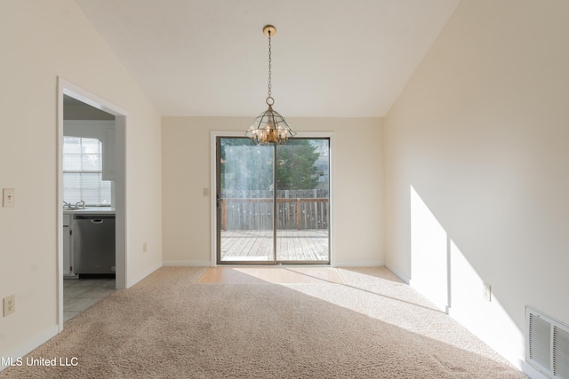 unfurnished dining area with plenty of natural light, vaulted ceiling, light carpet, and an inviting chandelier