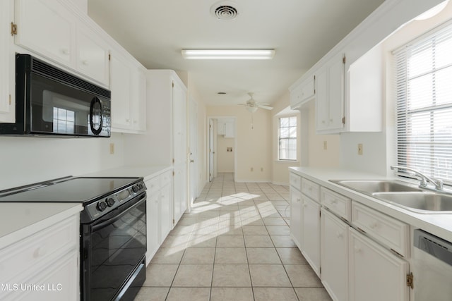 kitchen with light tile patterned floors, sink, white cabinetry, and black appliances