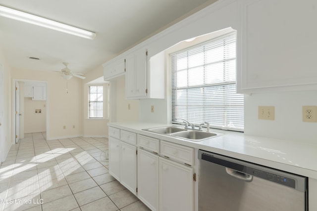 kitchen featuring stainless steel dishwasher, white cabinets, light tile patterned floors, and sink