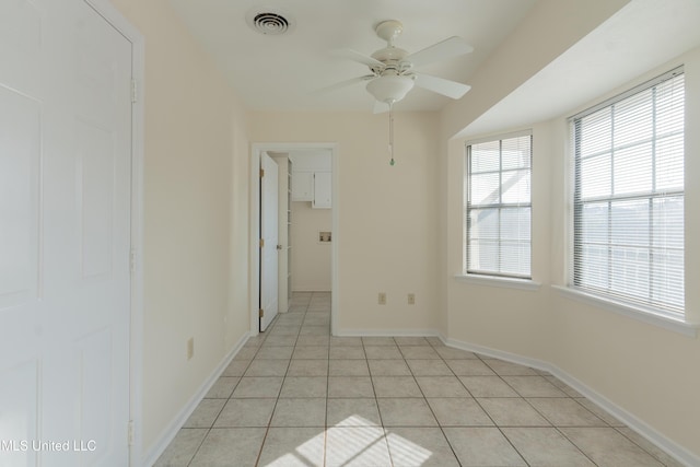 tiled empty room featuring ceiling fan