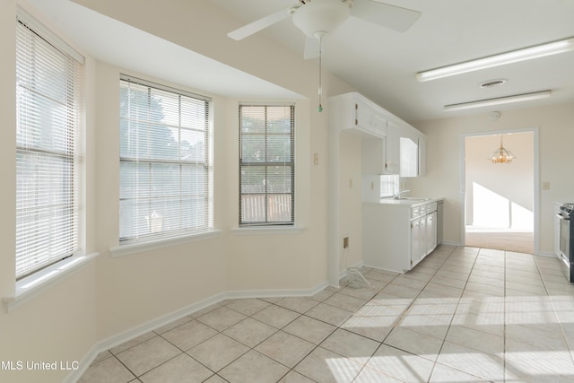 kitchen featuring white cabinetry, sink, hanging light fixtures, light tile patterned flooring, and ceiling fan with notable chandelier