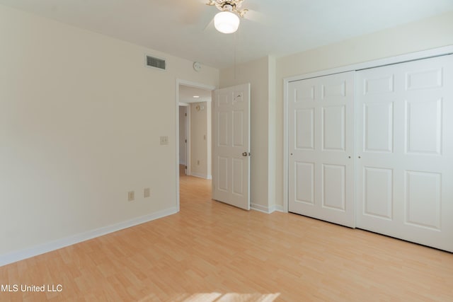 unfurnished bedroom with ceiling fan, a closet, and light wood-type flooring