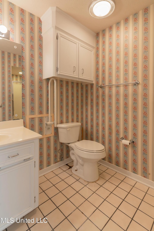 bathroom with tile patterned flooring, vanity, and toilet