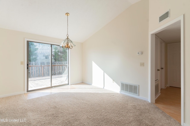 empty room featuring light colored carpet, lofted ceiling, and a notable chandelier