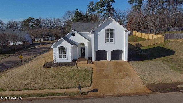 view of front of property with a garage, concrete driveway, a front yard, and stucco siding