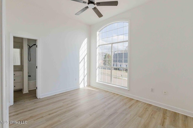 empty room featuring ceiling fan, light wood-style flooring, and baseboards