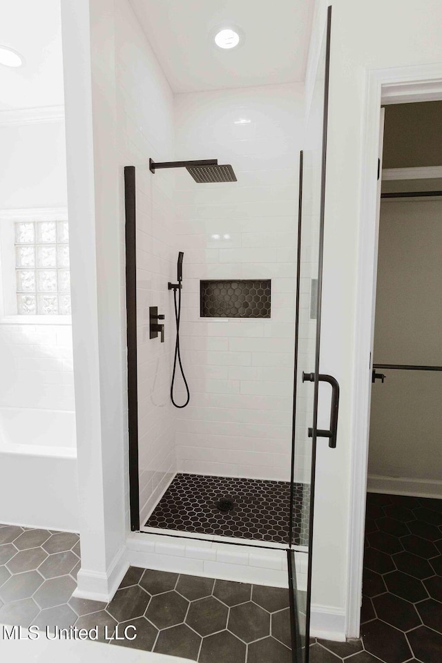 full bathroom featuring a shower stall, baseboards, and tile patterned floors