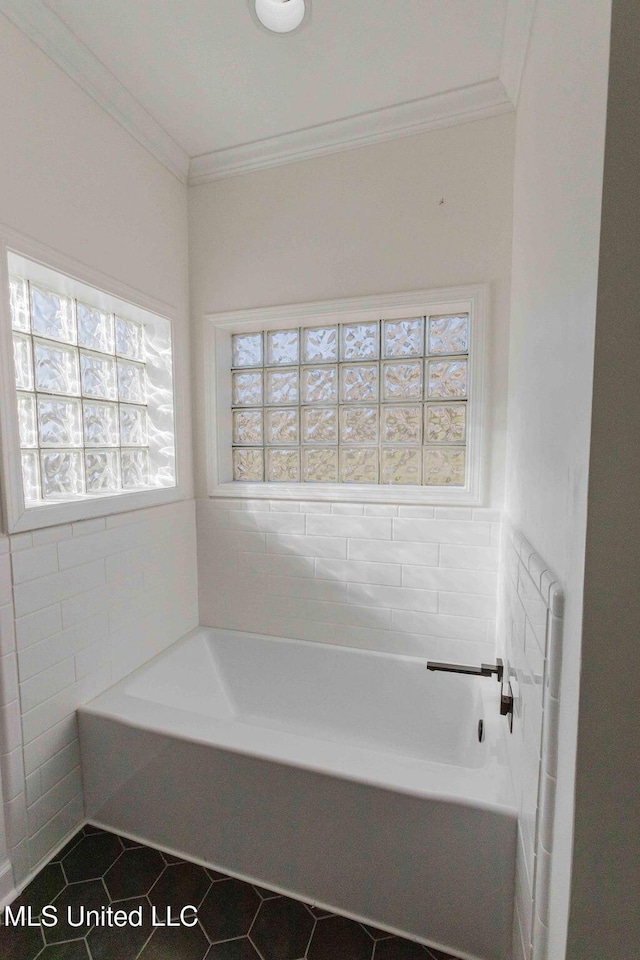 full bath with tile patterned flooring, a garden tub, and crown molding