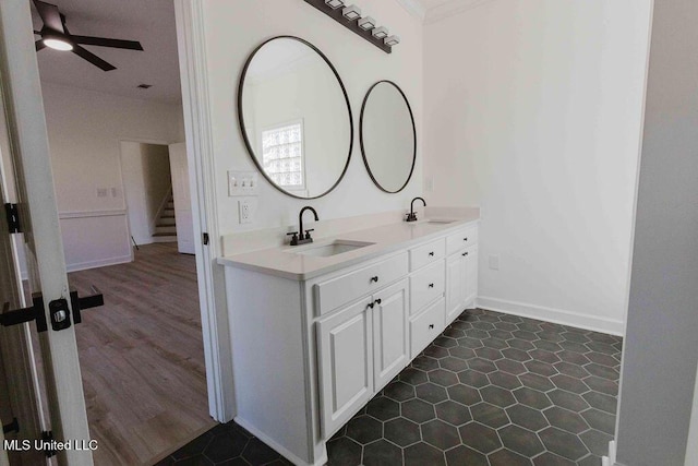 full bath with double vanity, a ceiling fan, a sink, and ornamental molding