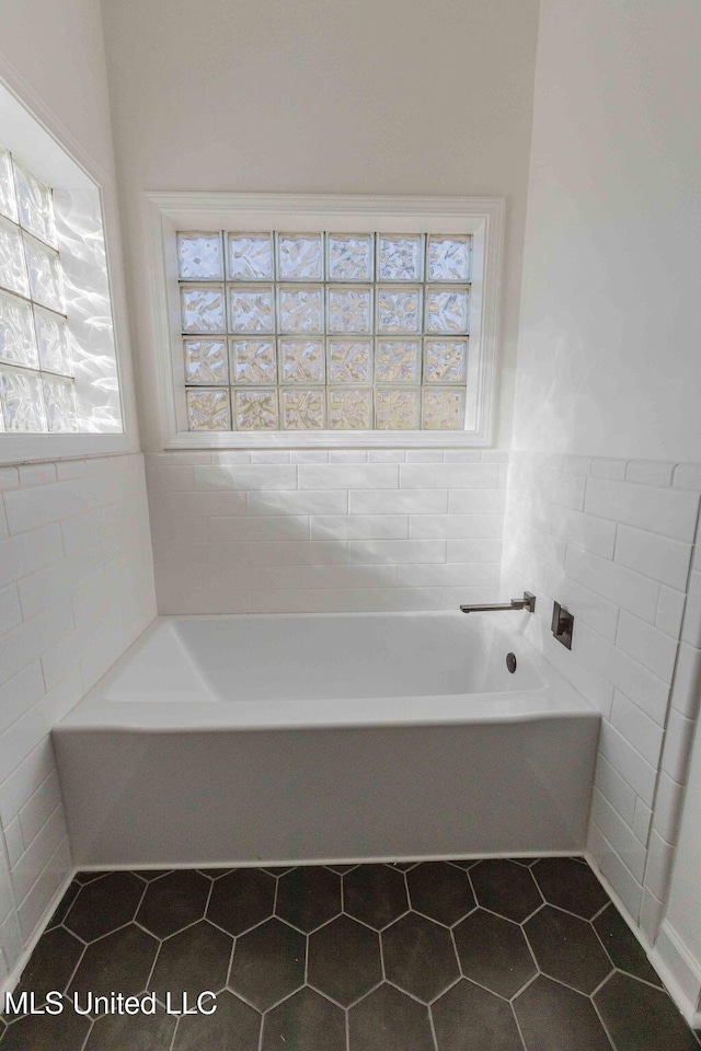 full bath featuring a garden tub, tile walls, and tile patterned floors