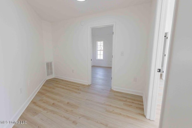 unfurnished room with baseboards, visible vents, and light wood-style floors