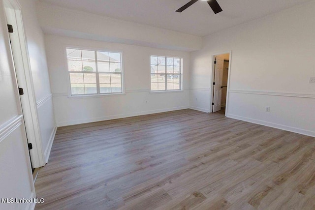 spare room featuring ceiling fan, baseboards, and light wood-style floors