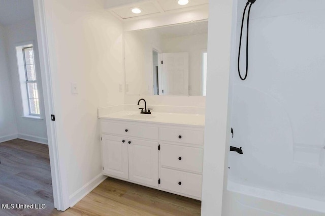 full bath with recessed lighting, wood finished floors, vanity, baseboards, and walk in shower