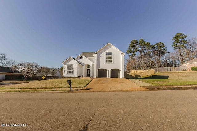 view of front of property featuring an attached garage, fence, concrete driveway, stucco siding, and a front yard