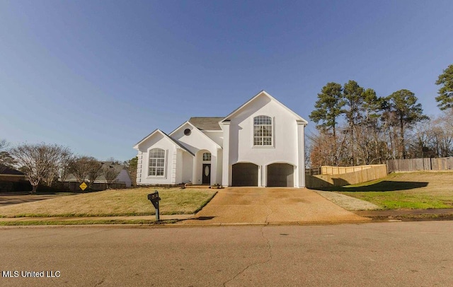 view of front of property featuring concrete driveway, an attached garage, fence, a front lawn, and stucco siding