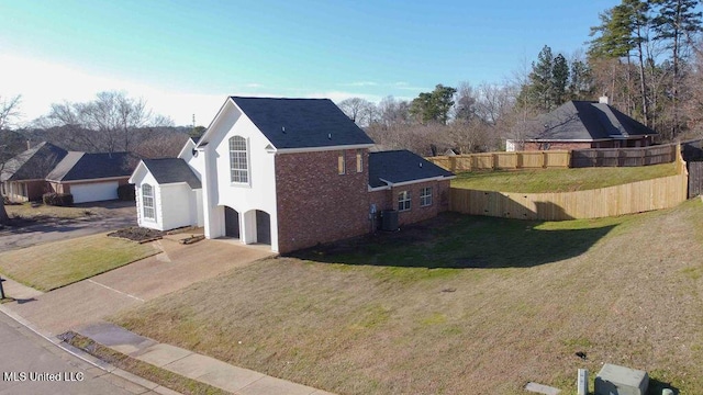 view of property exterior featuring stucco siding, concrete driveway, a lawn, fence, and a garage