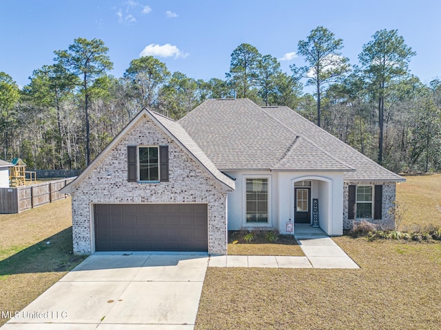 view of front facade featuring a shingled roof, concrete driveway, fence, a garage, and a front lawn