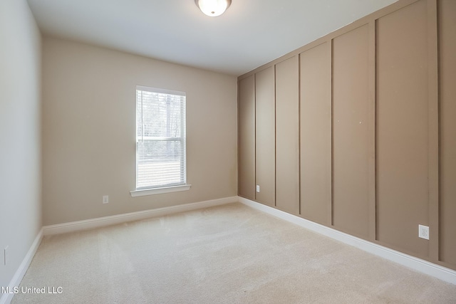 empty room featuring light carpet and baseboards