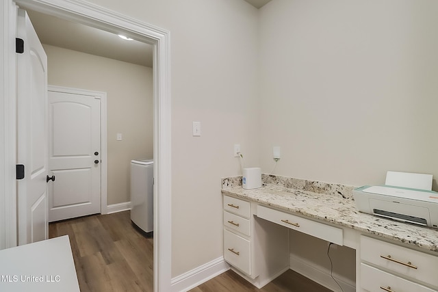 bathroom featuring baseboards, washer / clothes dryer, wood finished floors, and vanity