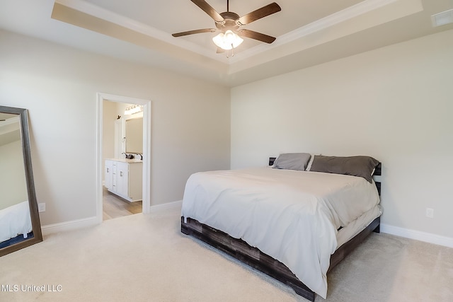 bedroom with connected bathroom, light carpet, visible vents, baseboards, and a tray ceiling