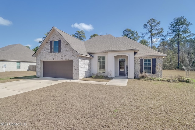 view of front of house with brick siding, a shingled roof, an attached garage, driveway, and a front lawn