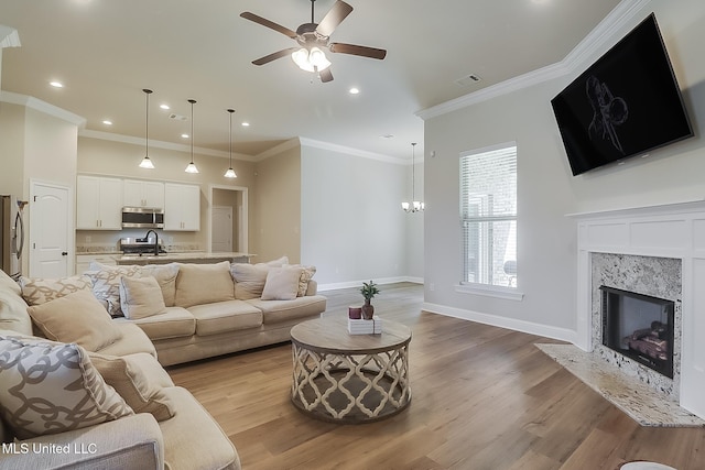 living room with light wood finished floors, a premium fireplace, visible vents, and baseboards