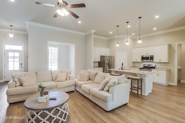 living room with recessed lighting, light wood-style flooring, ornamental molding, ceiling fan, and baseboards