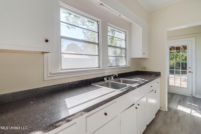 kitchen with a wealth of natural light, sink, white cabinets, and light wood-type flooring